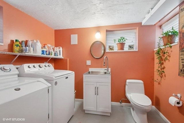 laundry room with baseboards, a textured ceiling, independent washer and dryer, laundry area, and a sink
