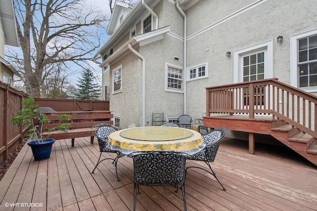 deck with a fenced backyard and outdoor dining area