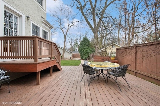 deck with outdoor dining space and fence