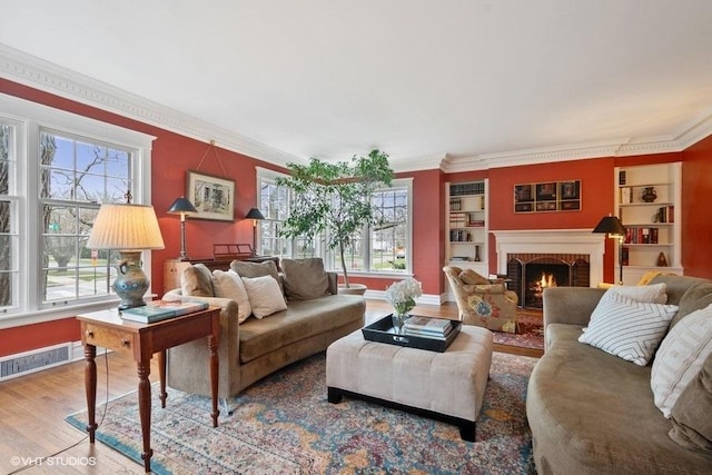 living area featuring a wealth of natural light, visible vents, crown molding, and wood finished floors
