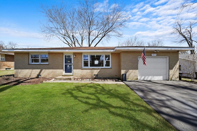 ranch-style home featuring brick siding, driveway, a garage, and a front lawn