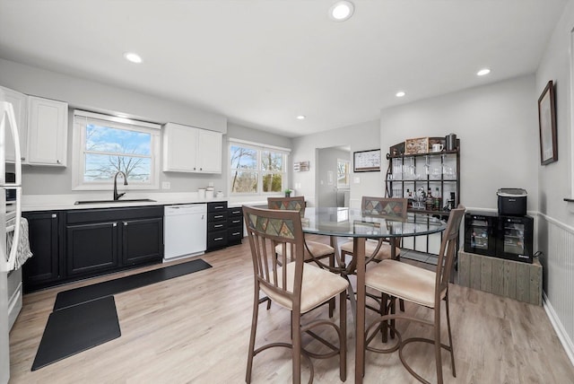 dining space featuring baseboards, light wood finished floors, and recessed lighting
