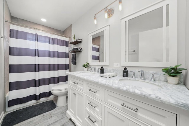 bathroom featuring a sink, toilet, double vanity, and a shower with curtain