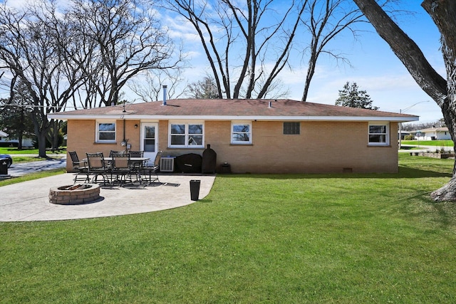 back of house with an outdoor fire pit, a lawn, a patio area, and brick siding