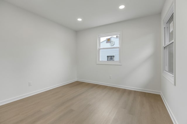 empty room featuring baseboards, light wood-style flooring, and recessed lighting