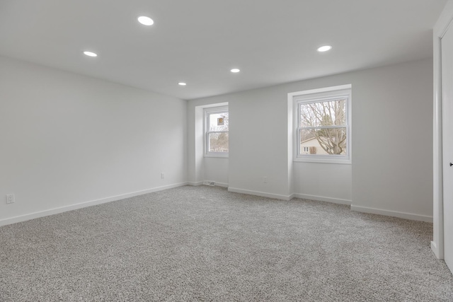 carpeted spare room featuring baseboards and recessed lighting