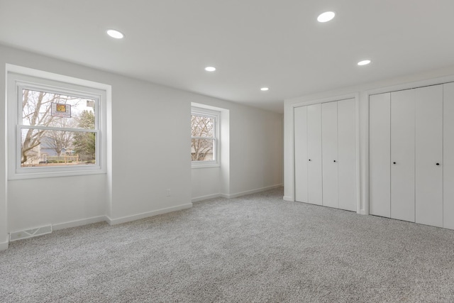 unfurnished bedroom featuring visible vents, two closets, carpet floors, and recessed lighting