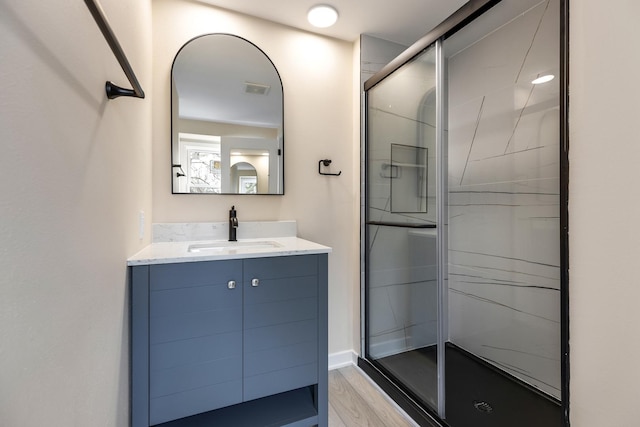 full bathroom with a stall shower, visible vents, wood finished floors, and vanity