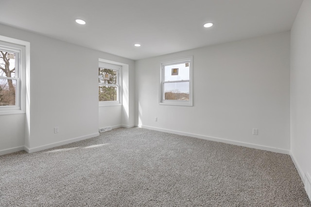 empty room with baseboards, visible vents, recessed lighting, and carpet flooring