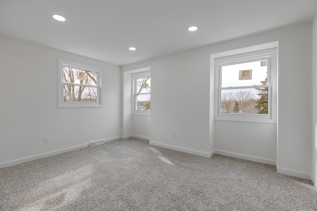 empty room featuring light carpet, baseboards, visible vents, and recessed lighting