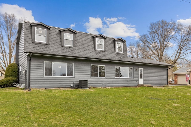 rear view of house featuring roof with shingles, central air condition unit, and a yard