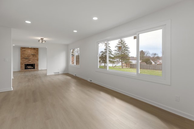 unfurnished living room featuring visible vents, baseboards, a fireplace, recessed lighting, and light wood-style floors
