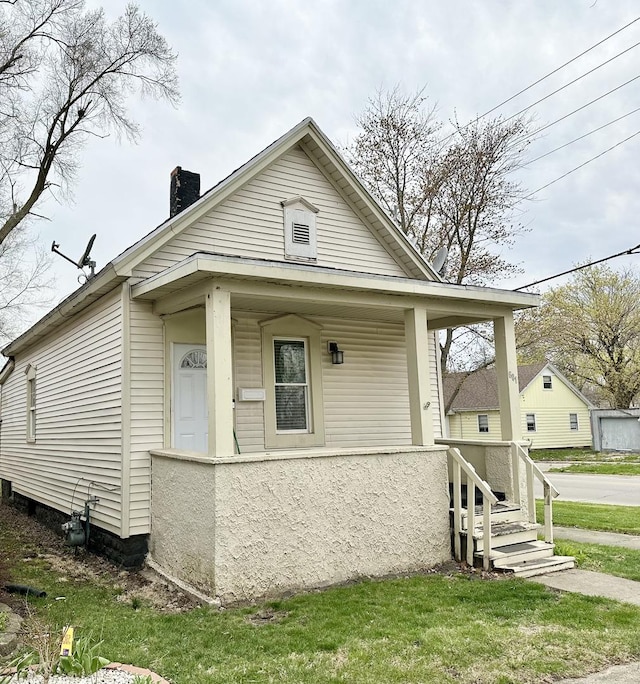 601 S Osborn Ave, Kankakee, IL 60901 - shotgun-style home with covered porch, a chimney, and a front lawn
