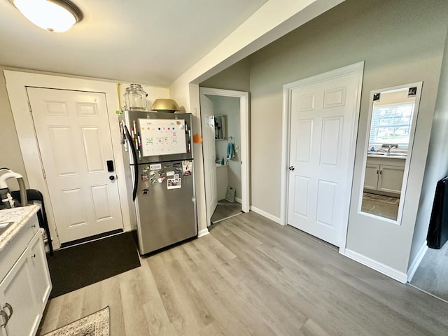 601 S Osborn Ave, Kankakee, IL 60901 - kitchen featuring freestanding refrigerator, light wood-type flooring, white cabinetry, light countertops, and baseboards