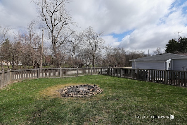 view of yard featuring a fenced backyard and a fire pit