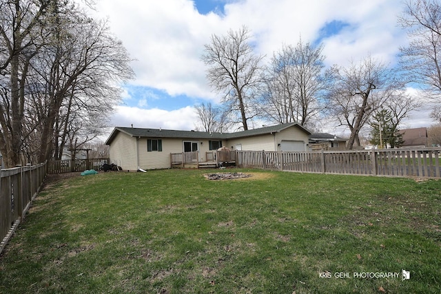 rear view of property with a yard, a fenced backyard, and a deck