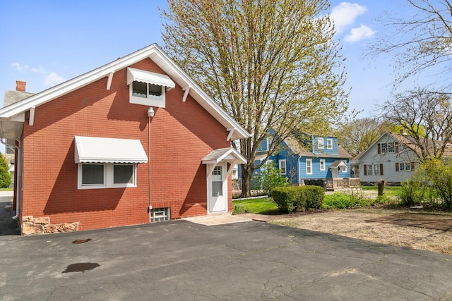 exterior space with a chimney and brick siding