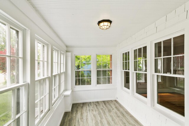 unfurnished sunroom with a wealth of natural light and wood finished floors