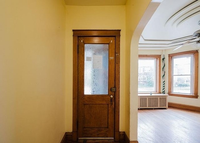 1228 S 59th Ave, Cicero, IL 60804 - entryway featuring radiator, arched walkways, baseboards, and wood finished floors