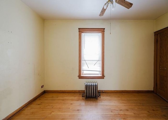1228 S 59th Ave, Cicero, IL 60804 - unfurnished room with radiator heating unit, a ceiling fan, baseboards, and light wood-style flooring