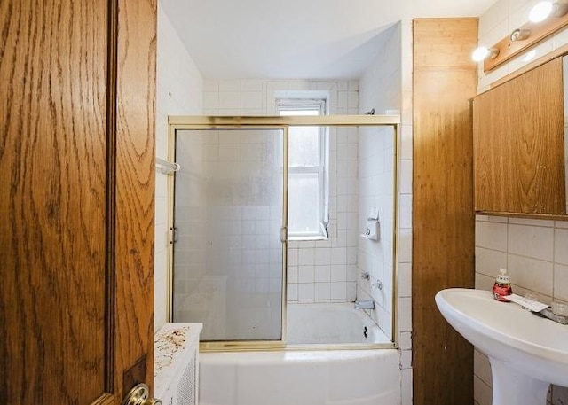 1228 S 59th Ave, Cicero, IL 60804 - bathroom with tile walls, bath / shower combo with glass door, and a sink