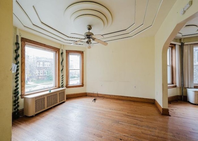 1228 S 59th Ave, Cicero, IL 60804 - unfurnished room with arched walkways, radiator heating unit, light wood finished floors, and baseboards