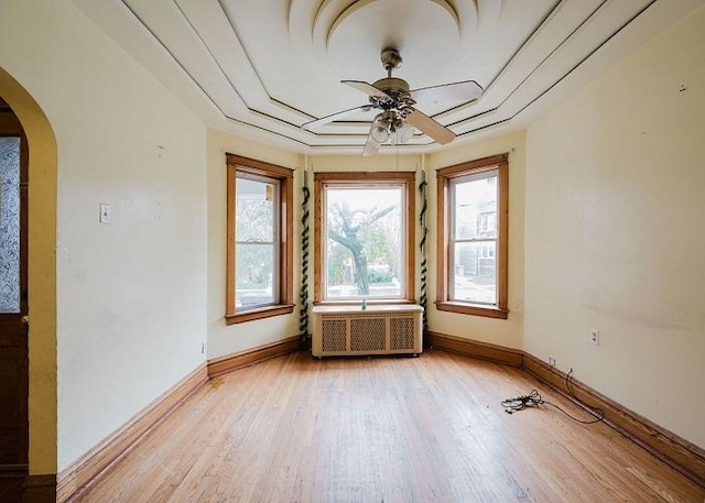 1228 S 59th Ave, Cicero, IL 60804 - unfurnished room featuring ceiling fan, arched walkways, light wood-style flooring, radiator, and baseboards