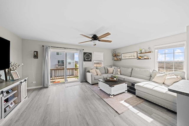 living area featuring a ceiling fan, a healthy amount of sunlight, and light wood-style floors
