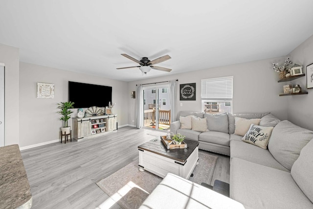 living room with baseboards, ceiling fan, and wood finished floors