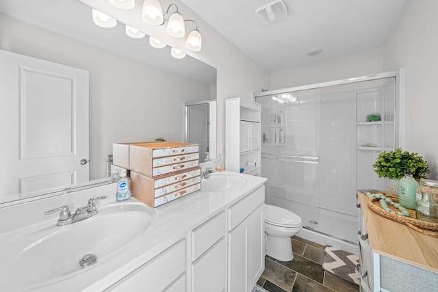bathroom with double vanity, visible vents, a shower stall, and a sink