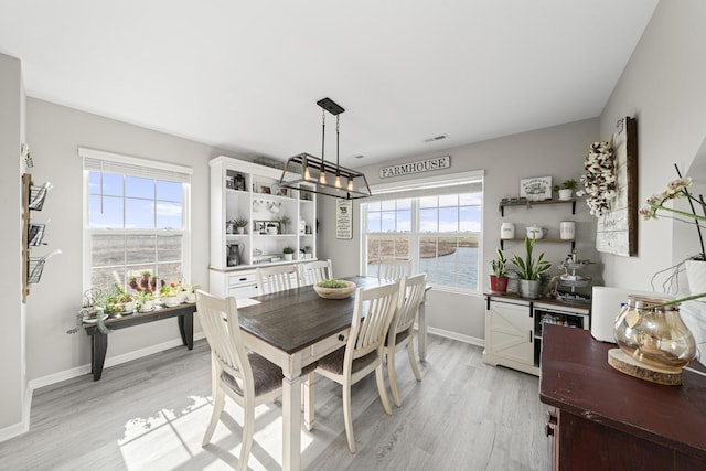 dining area with baseboards, visible vents, and light wood-style flooring