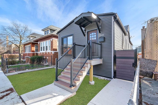view of front facade featuring a front yard, fence, and a gate