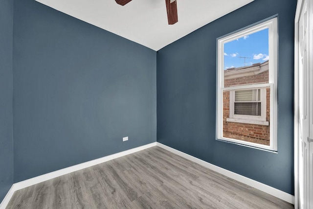 unfurnished room with baseboards, a ceiling fan, and wood finished floors