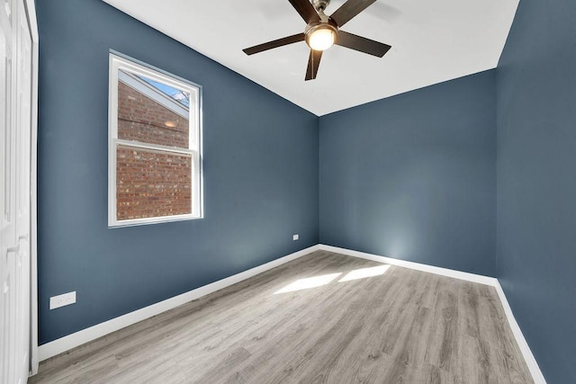 spare room featuring baseboards, a ceiling fan, and wood finished floors