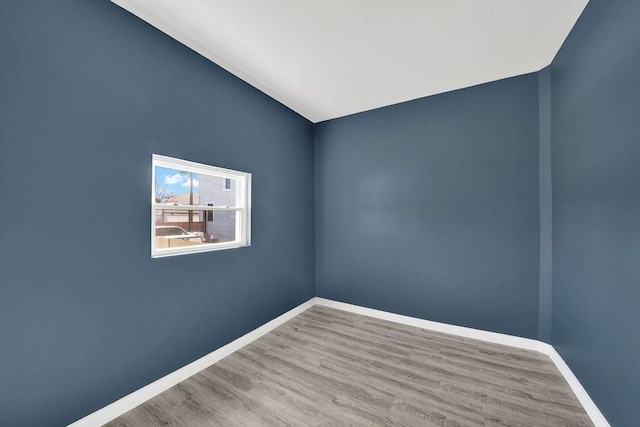 empty room with baseboards and wood finished floors