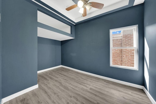 spare room with baseboards, a ceiling fan, and wood finished floors