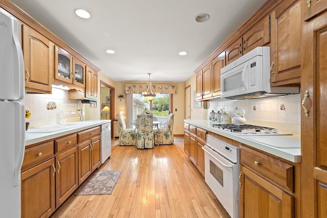 5 Saint Moritz Dr Unit 101, Palos Park, IL 60464 - kitchen featuring white appliances, backsplash, brown cabinets, a sink, and recessed lighting