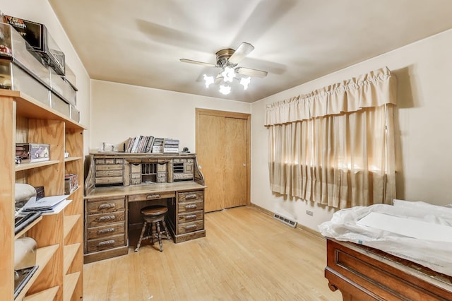 office space with wood finished floors, a ceiling fan, and visible vents