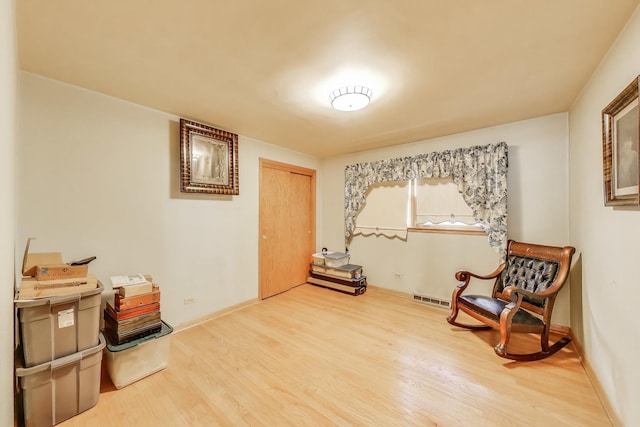 living area with wood finished floors and visible vents