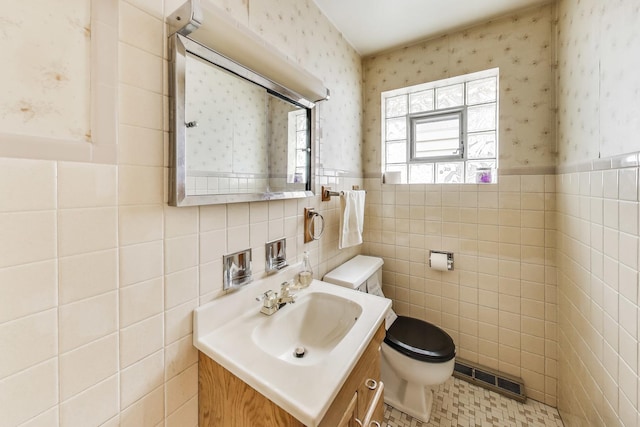 bathroom with toilet, wallpapered walls, and visible vents