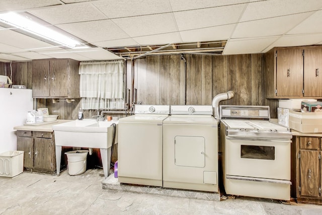 laundry area with wooden walls, washer and dryer, and laundry area