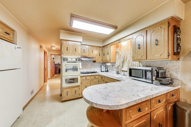 kitchen with light countertops, under cabinet range hood, visible vents, decorative backsplash, and stainless steel appliances