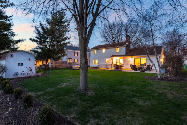 69 S Parkway Dr, Naperville, IL 60540 - rear view of property featuring a patio, a chimney, a storage unit, a lawn, and an outbuilding