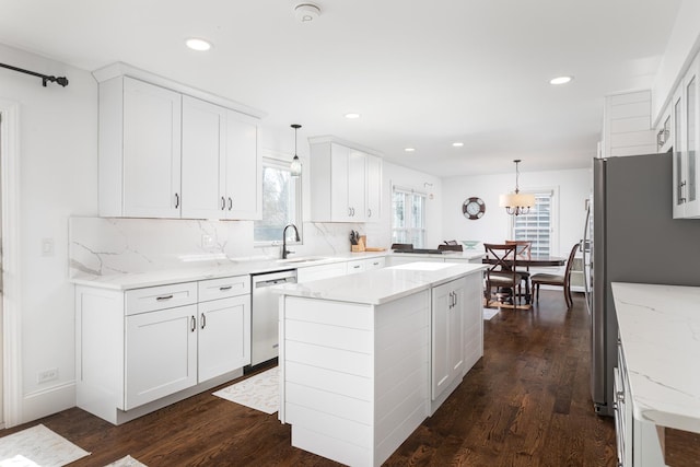 69 S Parkway Dr, Naperville, IL 60540 - kitchen featuring appliances with stainless steel finishes, a sink, a peninsula, tasteful backsplash, and dark wood-type flooring