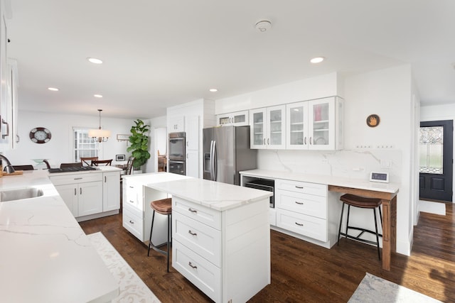 69 S Parkway Dr, Naperville, IL 60540 - kitchen featuring a kitchen island, glass insert cabinets, a breakfast bar area, white cabinets, and appliances with stainless steel finishes