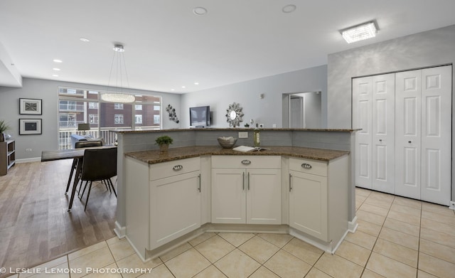 8400 Callie Ave Unit 402, Morton Grove, IL 60053 - kitchen featuring white cabinetry, light tile patterned floors, and dark stone countertops