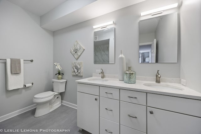 8400 Callie Ave Unit 402, Morton Grove, IL 60053 - bathroom featuring double vanity, toilet, baseboards, and a sink