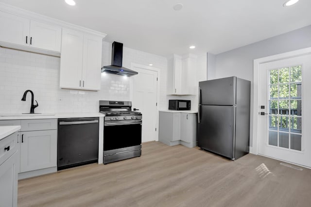 2134 W Shakespeare Ave, Chicago, IL 60647 - kitchen with light countertops, light wood-style flooring, wall chimney range hood, a sink, and black appliances