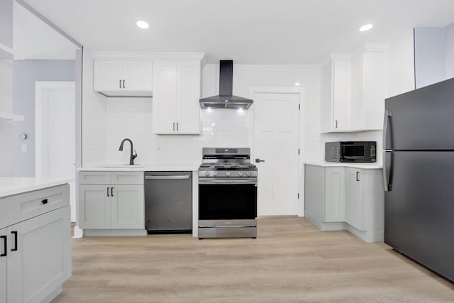2134 W Shakespeare Ave, Chicago, IL 60647 - kitchen featuring light countertops, light wood-style flooring, appliances with stainless steel finishes, a sink, and wall chimney range hood