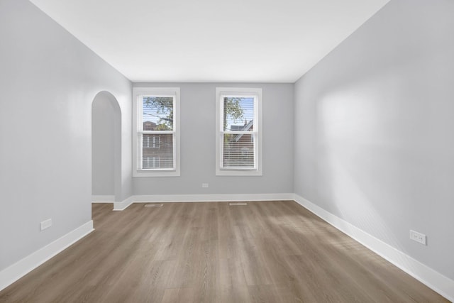 2134 W Shakespeare Ave, Chicago, IL 60647 - spare room with baseboards, visible vents, wood finished floors, and arched walkways